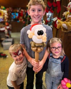 Three Happy Kids with a Santa Balloon